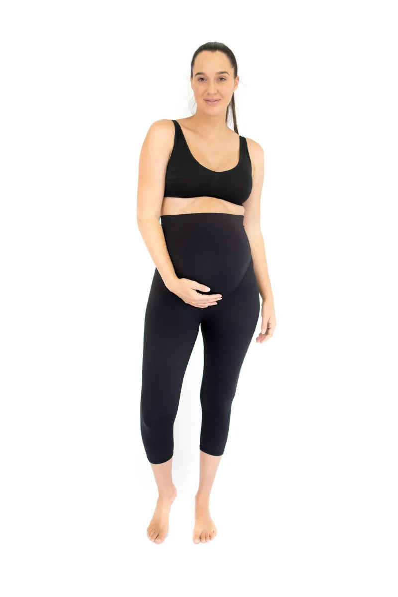 Woman from waist down wearing black high-waisted 3/4 body shapewear leggings with pockets.
